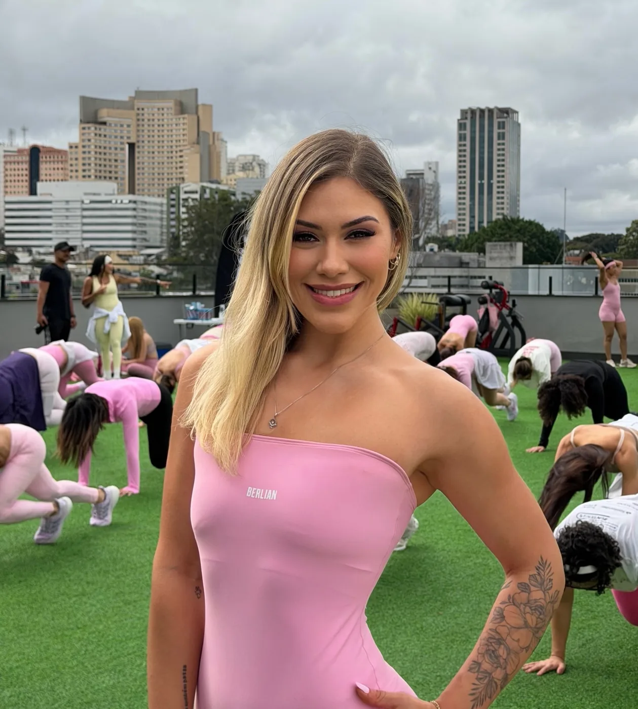 Bre Cardoso de vestido rosa no gramado do rooftop durante a primeira edição da LOOUE