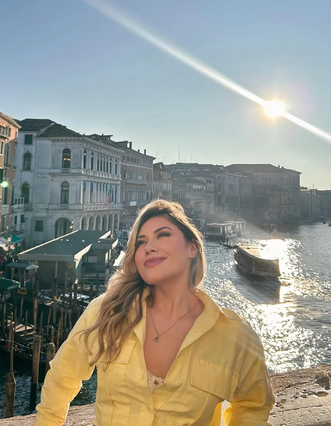 Bre Cardoso de jaqueta amarela diante do Grande Canal em Veneza